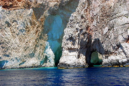 grey rock formations near body of water during daytime thumbnail