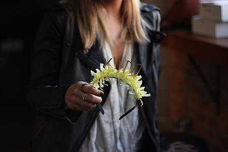 woman holding headband with yellow flower accent thumbnail