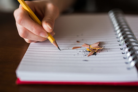 person writing on notebook using pencil thumbnail