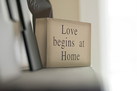 selective focus photography of love begins at home decorative wood block on white shelf thumbnail