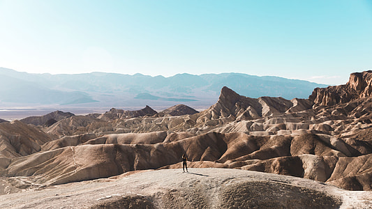 man standing in front of rocky mountains thumbnail