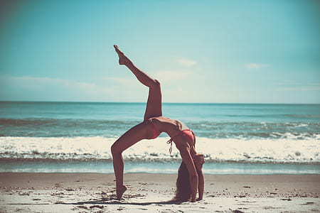 photo of woman bend on sand near beach thumbnail