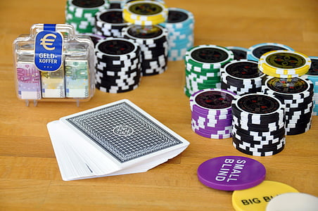 assorted-color poker chip and playing card set on table thumbnail