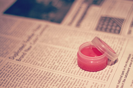 clear plastic container on white printed newspaper thumbnail