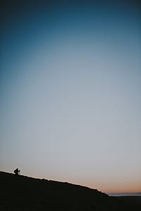 person on mountain under golden hour thumbnail