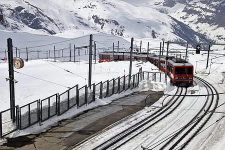 red train on railway during winter at daytime thumbnail