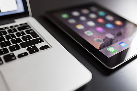 space gray iPad beside silver MacBook on black table thumbnail