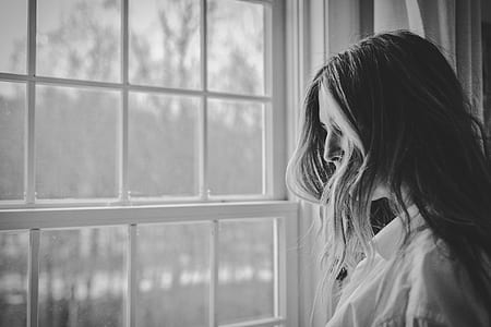 grayscale photo of woman near window thumbnail