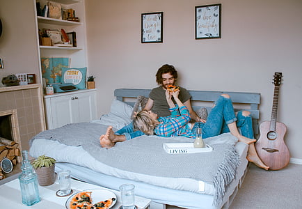 man sitting on bed beside woman lying thumbnail
