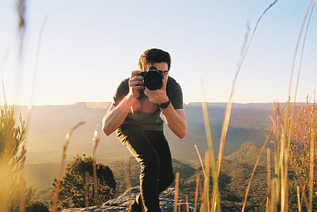 man taking photo standing near cliff thumbnail
