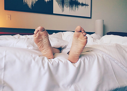 person lying on the bed covered with a white blanket thumbnail
