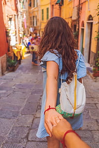 couple holding together while walking on street during day time thumbnail