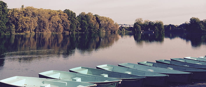 empty white canoe on body of water near trees thumbnail