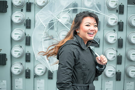 smiling woman with umbrella near wall thumbnail