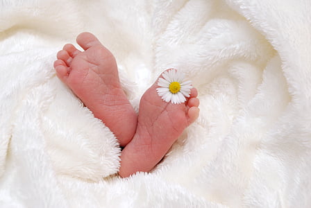 person's feet with white daisy on left foot thumbnail