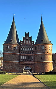 group of people standing in front of brown painted castle thumbnail