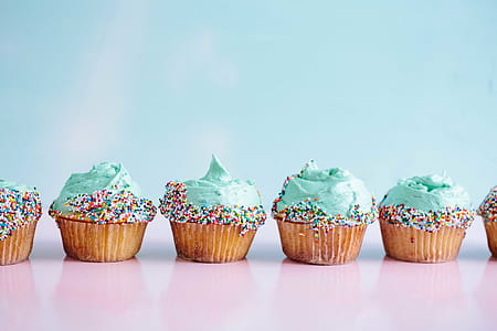 six lined up green cupcakes topped with sprinkles thumbnail