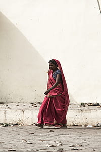 woman in red dress walking near wall thumbnail