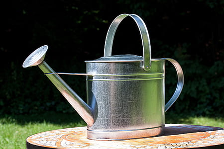 closeup photography of gray stainless steel watering can on table during daytime thumbnail