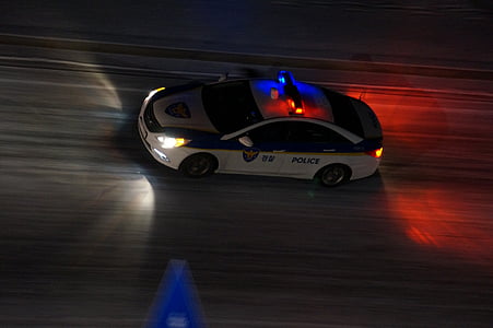 white Police sedan on road at night time thumbnail