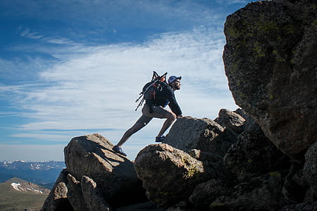 man wearing cap and backpack during daytime thumbnail