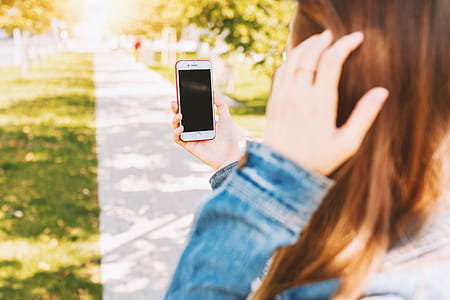Mockup image of a woman using smartphone with blank black screen at outdoor thumbnail