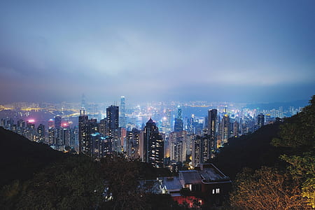 aerial view of lighted buildings beside mountain thumbnail