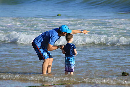 man and boy standing on shore thumbnail