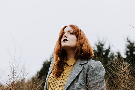 woman standing on grass field near fores thumbnail