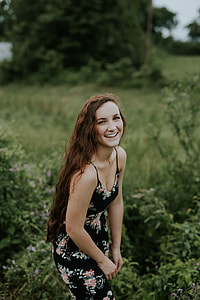 smiling woman wearing black and peach floral spaghetti-strap dress thumbnail