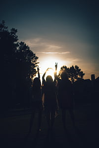silhouette photo of three woman raising their arms thumbnail