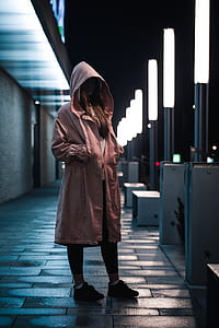 woman standing in the middle of street during night time thumbnail