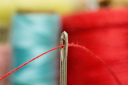 selective focus photography of red thread in needle thumbnail