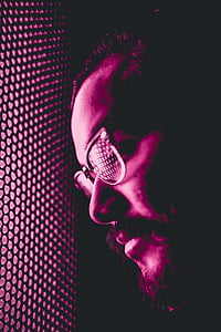 man wearing eyeglasses while leaning his face on wall thumbnail