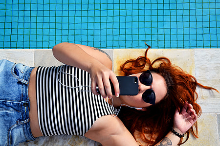 woman lying on ground holding black iPhone thumbnail