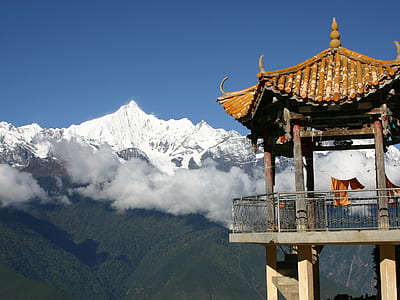 brown wooden tower near mountain thumbnail
