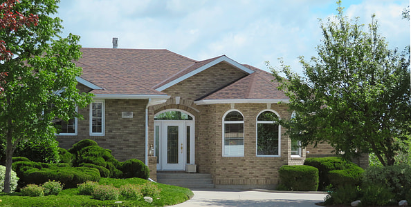 beige concrete house surrounded by green trees thumbnail