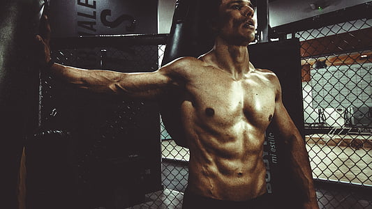 topless man leaning on black surface thumbnail
