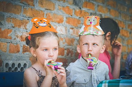 girl and boy wearing animal themed party hats thumbnail