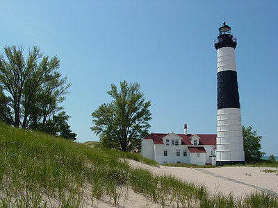 white and black lighthouse near house thumbnail