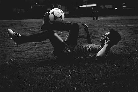 grayscale photography of man making tricks to soccer ball thumbnail