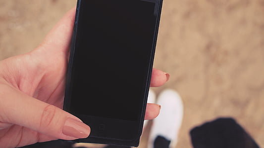 person holding black iPhone 5 with black screen thumbnail