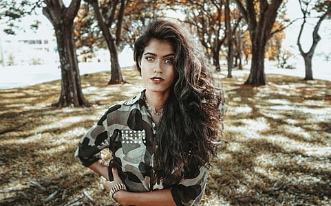 woman standing in between the trees during daytime thumbnail