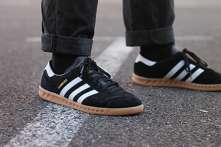 person wearing black-and-brown adidas Superstar shoes thumbnail