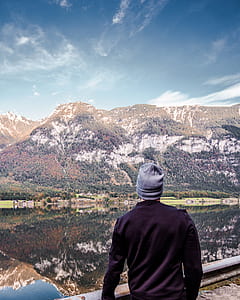 person wearing gray beanie standing near mountain thumbnail