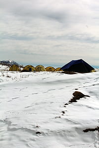 blue and yellow tents camping on snow field at daytime thumbnail
