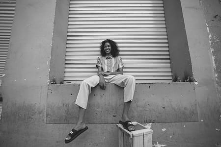 Woman in White Pants and Pair of Black Nike Benassi Slides thumbnail