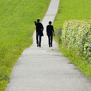 two people walking on path near green grass thumbnail