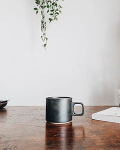 black ceramic mug on brown wooden table thumbnail
