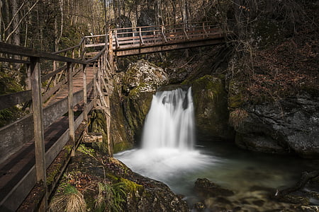 time lapse photo of waterfalls under brown wooden bridge during daytime thumbnail